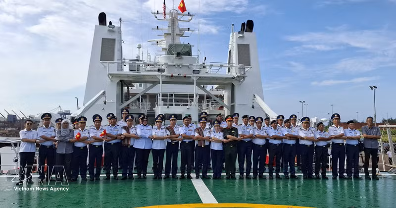 越南海警代表与马来西亚海事执法局（MMEA）彭亨州代表在CSB 8005号舰上，按东盟传统进行合影留念。（图片来源：越通社）