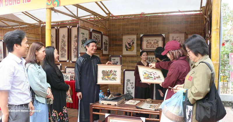 向游客介绍北宁的东湖画。（图片来源：越通社）