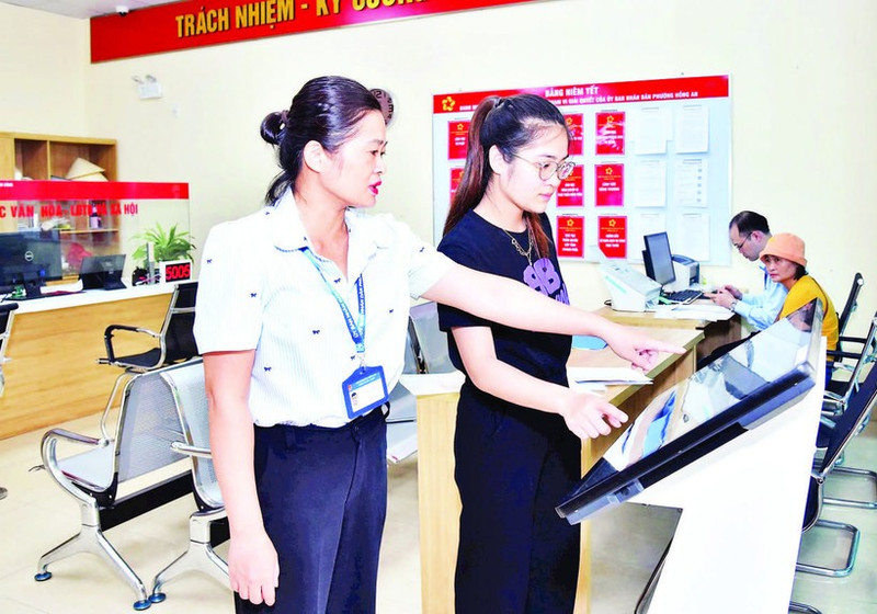 海防市红安坊公共行政服务中心干部职工正在引导群众通过线上方式办理行政手续。