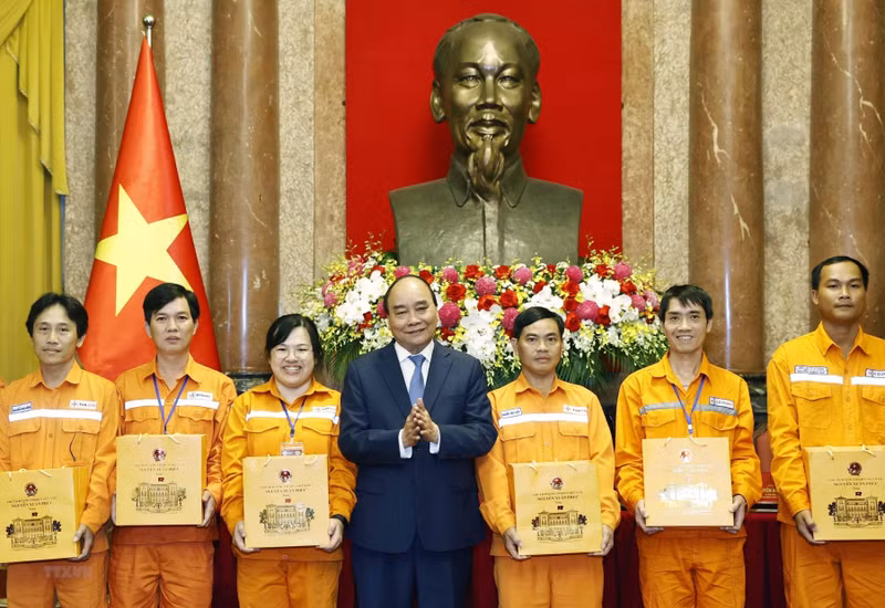 越南国家主席阮春福向电力优秀员工赠送慰问品。（图片来源：越通社）