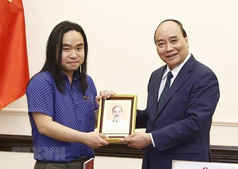 越南国家主席阮春福在主席府会见了在美越南留学生、文学领域青年人才阮平。（图片来源：越通社）