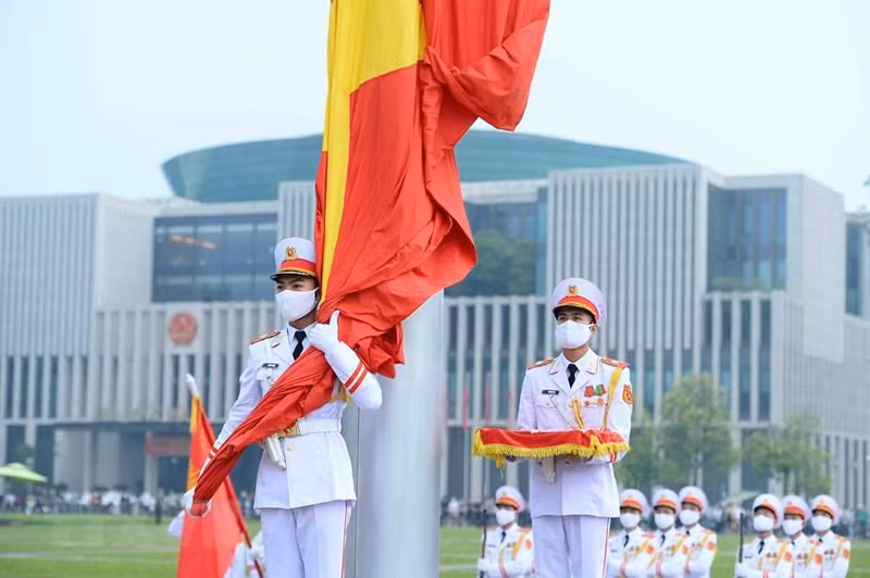 红旗队的战士们庄严地走上讲台，准备进行正式仪式。5时59分，战士举起国旗挂在旗杆上。 （图片来源：越通社）