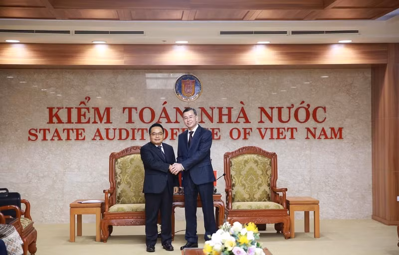 越南国家审计署副审计长吴文俊（右）与老挝国家审计署审计长亲切握手。（图片来源：越通社）