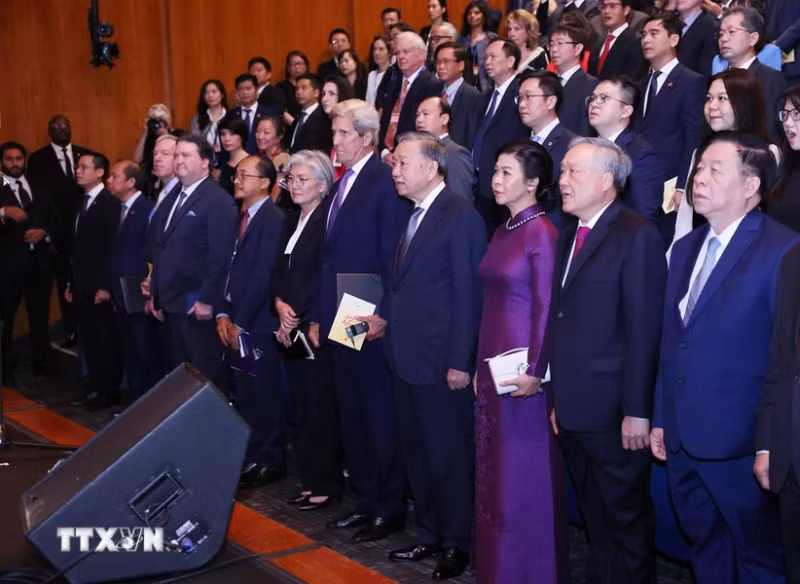 越共中央总书记、国家主席苏林同夫人和各位代表唱起越南国歌。（图片来源：越通社）