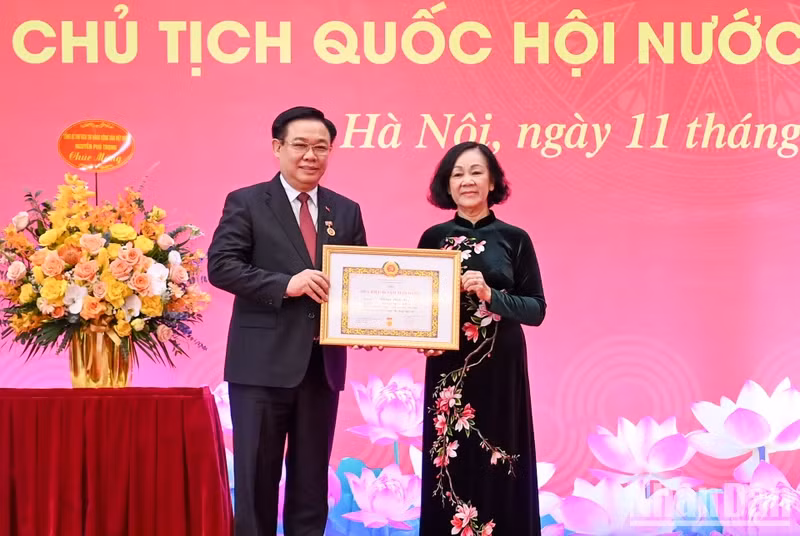 越共中央政治局委员、中央书记处常务书记、中央组织部部长张氏梅向国会主席王廷惠颁发40周年党龄纪念章。