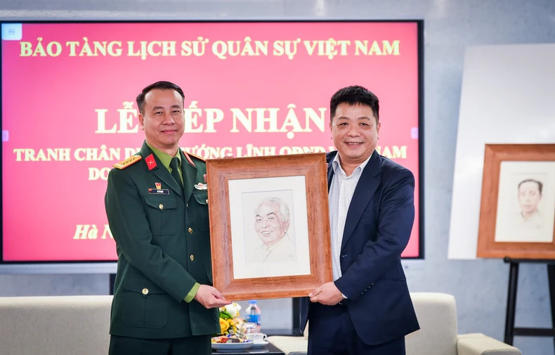《人民报》社副总编辑桂廷原向越南军事历史博物馆馆长黎武辉赠送杰出将领画作。