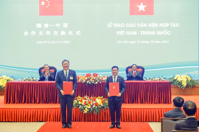 越南工贸部长阮鸿延与中国商务部部长王文涛在越南政府总理范明正和中国国务院总理李强的见证下交换了两份合作文件。（图片来源：越通社）