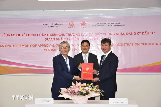 安沛省人民委员会主席陈辉俊向日本Erex集团总裁Honna Hitoshi颁发了有关批准安沛一号生物质发电项目投资主张和投资商的决定。（图片来源：越通社）