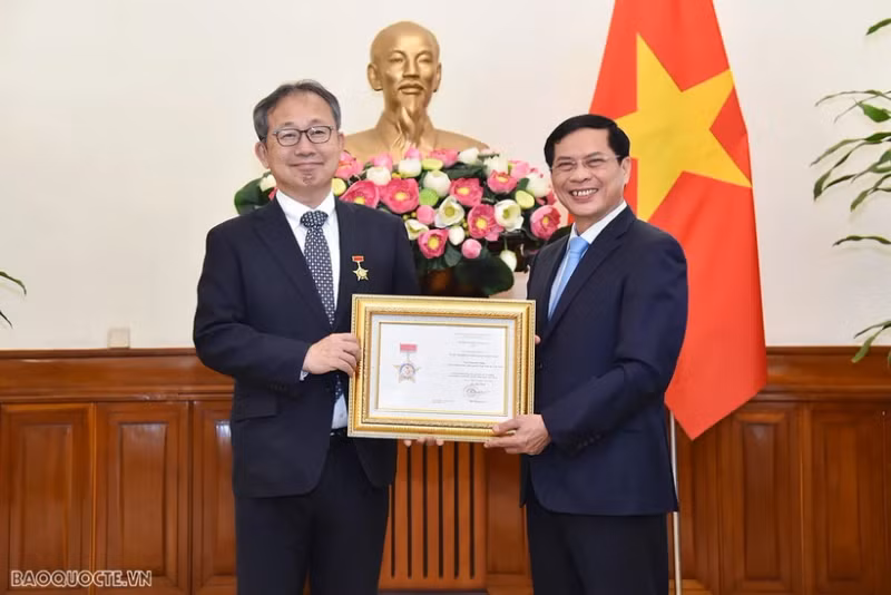 裴青山部长向山田贵雄大使授予“致力于越南外交事业”纪念章。（图片来源：国际报）