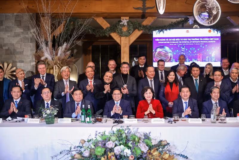 范明正总理同出席题为“投入越南金融市场的潜力和机会”座谈会的代表们合影。