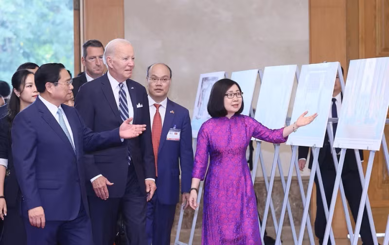越通社副社长段氏雪绒向范明正总理和拜登总统介绍由越通社举行的图片展（2023年9月）。