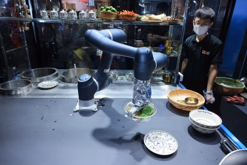 参加“河内数字河粉”活动的河内居民和游客可品尝由智能机器人准备和服务的传统河粉。（图片来源：越通社）
