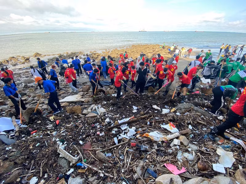 志愿者和游客参与清理海滩垃圾活动。