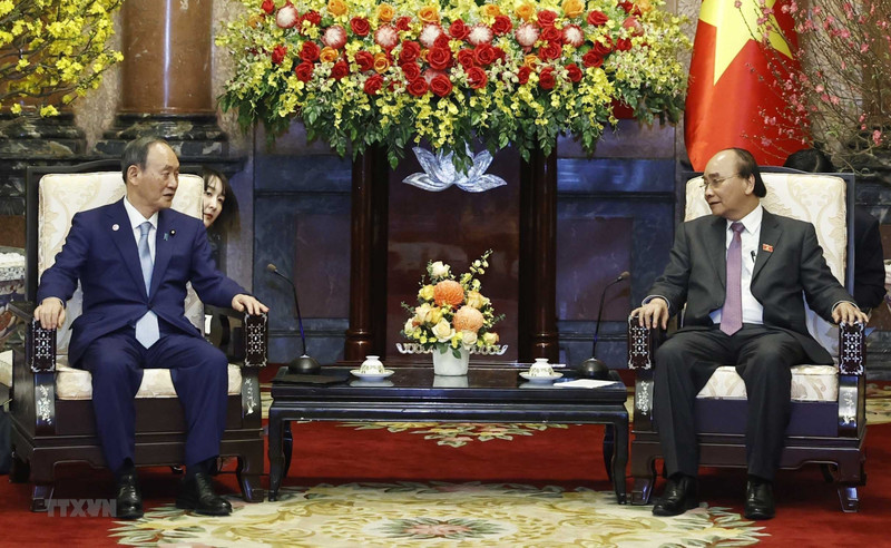 越南国家主席阮春福会见日本前首相菅义伟。（图片来源：越通社）
