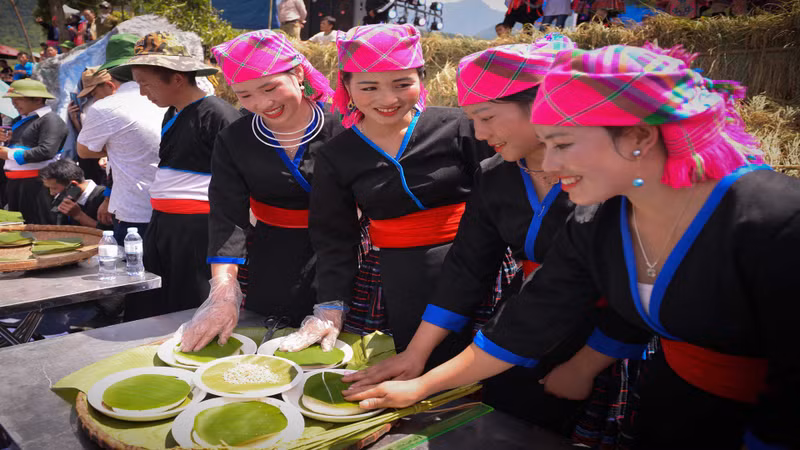 人们用香蕉叶把被舂至绵软柔韧的糯米饭按圆形包起来。 人们用香蕉叶把被舂至绵软柔韧的糯米饭按圆形包起来。