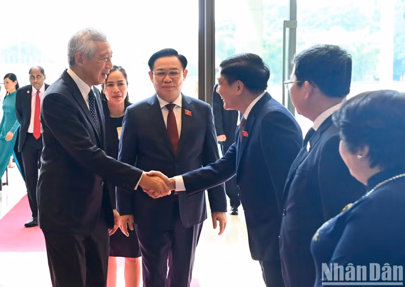 国会主席王廷惠向李显龙总理介绍出席会见的越方代表。