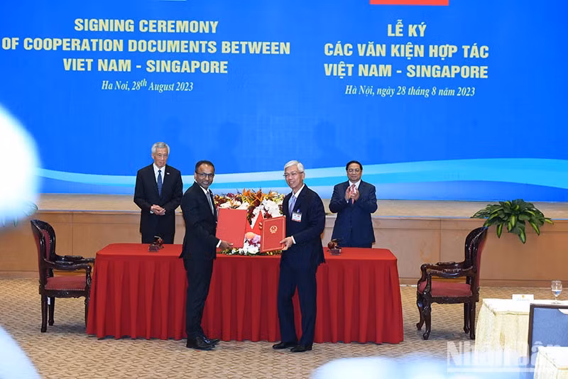 范明正总理和李显龙总理见证越南胡志明市人委会同新加坡亚洲基础设施办公室关于促进胡志明市基础设施可持续发展的合作备忘录的签署。