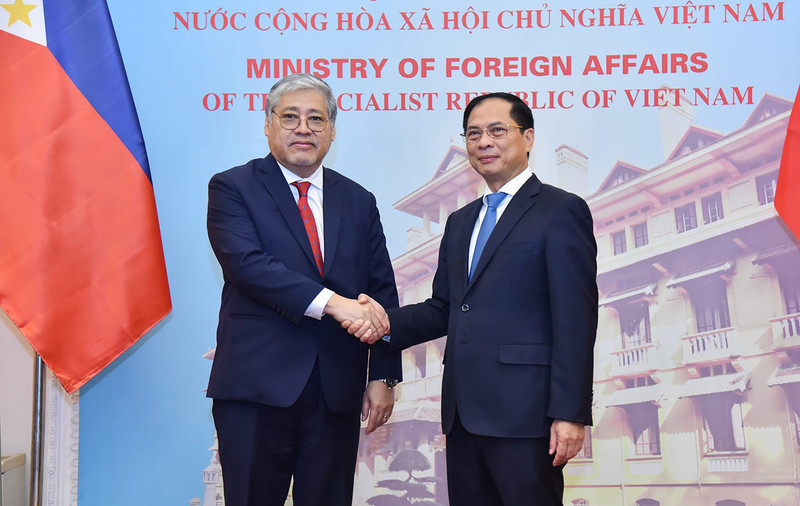 越南外交部长裴青山与菲律宾外交部长恩里克·马纳洛亲切握手。（图片来源：国际报）