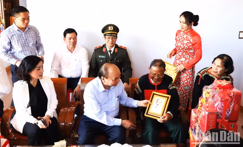 阮春福主席向奔胡市安乐坊的一位荣军赠送礼物。