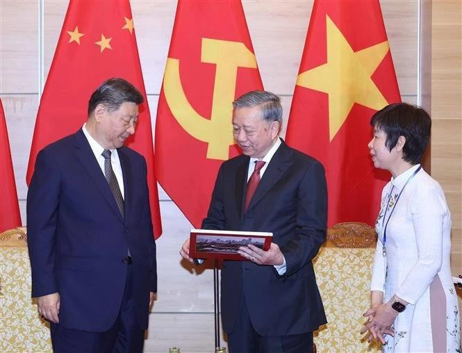 苏林总书记向中共中央总书记、国家主席习近平赠送越南通讯社出版有关习近平同志历次访越的画册。（图片来源：越通社）