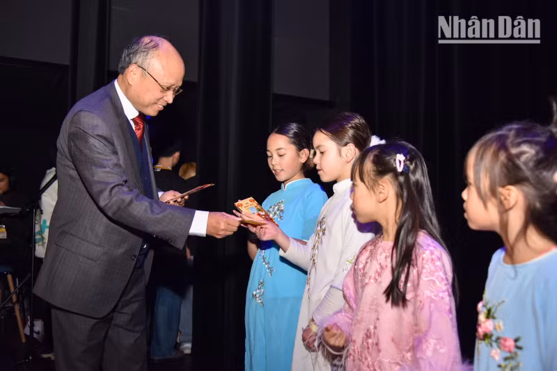 丁全胜大使向儿童们发放红包。