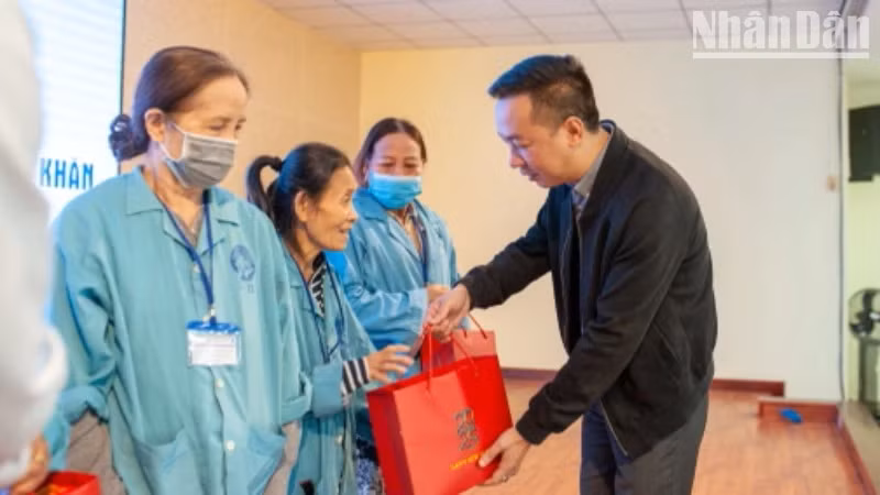 越南《人民报》社办公厅主任武黄永向患者赠送礼物。
