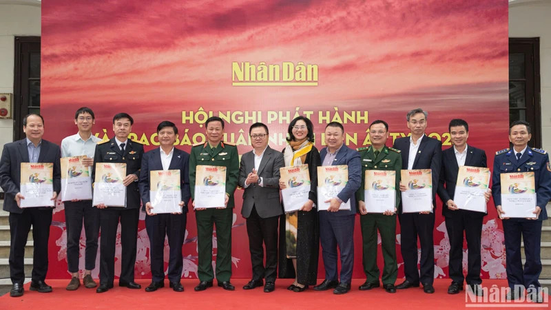 《人民报》社总编辑黎国明和部分单位代表向各单位代表赠送春节特刊。