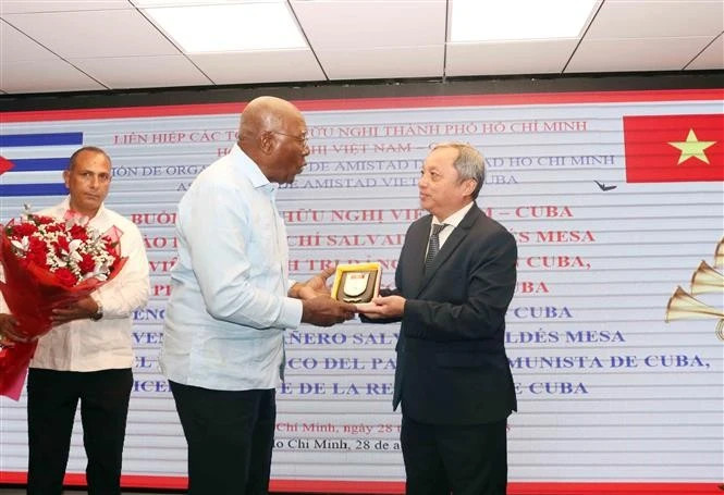 胡志明市友好组织联合会主席杜越何向古巴共产党中央政治局委员、国家副主席萨尔瓦多•瓦尔德斯•梅萨赠送纪念品。（图片来源：越通社）