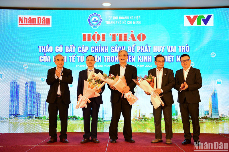 越南《人民报》社总编辑黎国明和胡志明市企业协会主席阮玉和向与会专家送上鲜花。（世阳 摄）