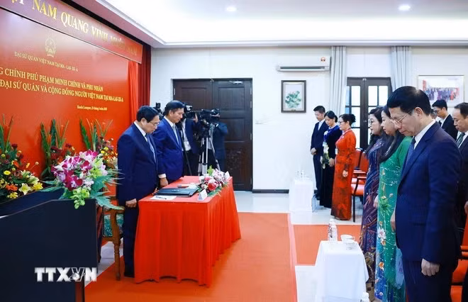范明正总理和夫人与越南驻马来西亚大使馆工作人员以及旅马越南人社群代表一同向原国家主席陈德良默哀致敬。（图片来源：越通社）