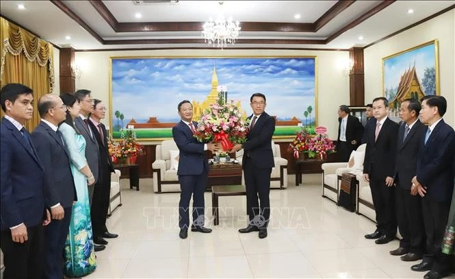 越南驻老挝大使阮明心移交苏林总书记送来的花篮，祝贺老挝人民革命党成立70周年。（图源：越通社）