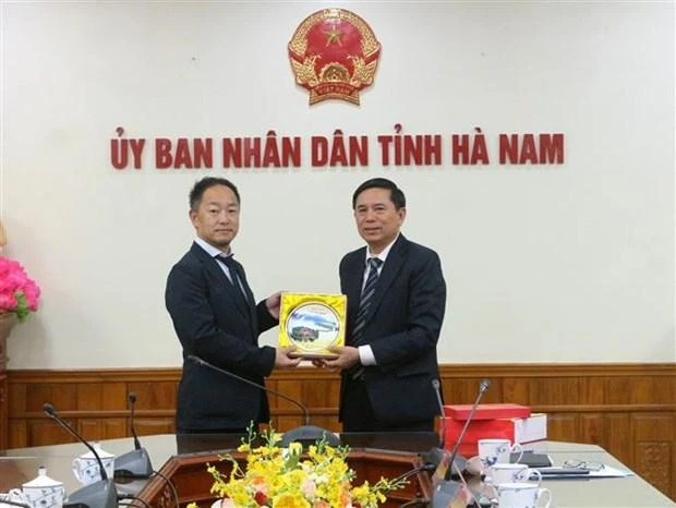 河南省人民委员会副主席陈春养向泉大津市市长办公室主任赠送纪念品。（图片来源：越通社）