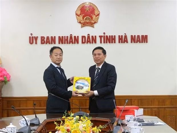 河南省人民委员会副主席陈春养向泉大津市市长办公室主任赠送纪念品。（图片来源：越通社）