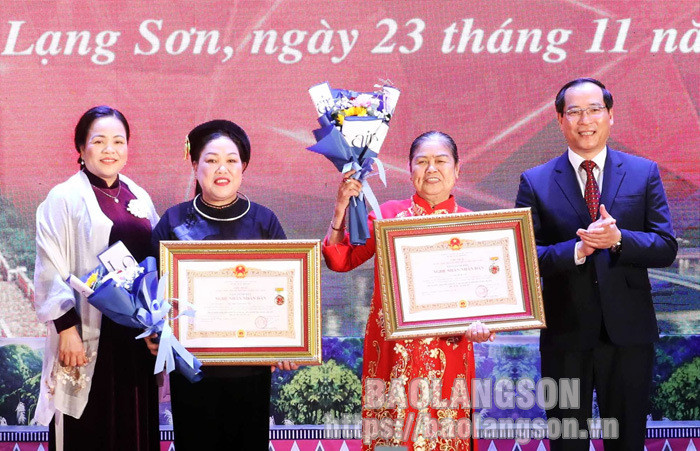 谅山省人民委员会常务副主席杨春煊及省委民运部部长甲氏北向2位“人民艺人”赠送鲜花并授予称号。（图片来源：谅山报）