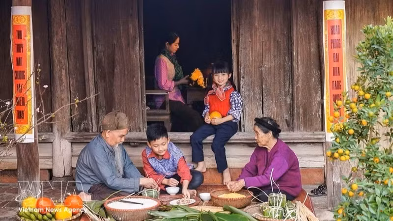 资料图：全家人聚在一起包粽子迎新春。（图片来源：越通社）
