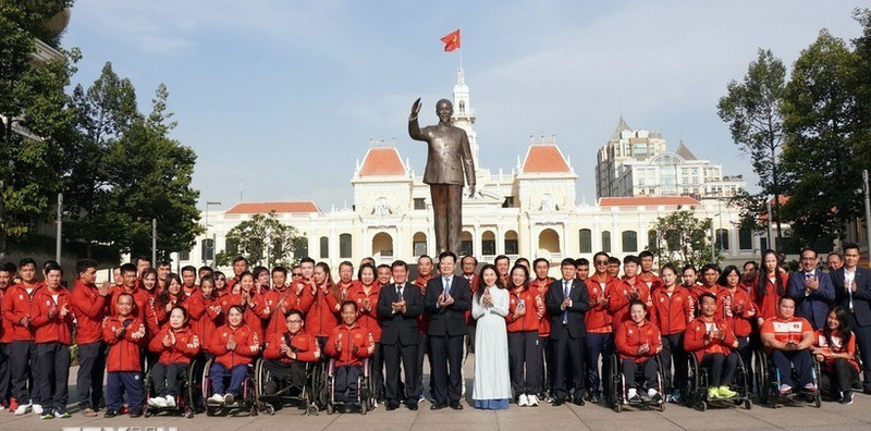 越南政府副总理梅文正与胡志明市各部委、机构代表以及越南残疾人体育代表团在胡志明主席纪念公园合影。（图片来源：越通社）