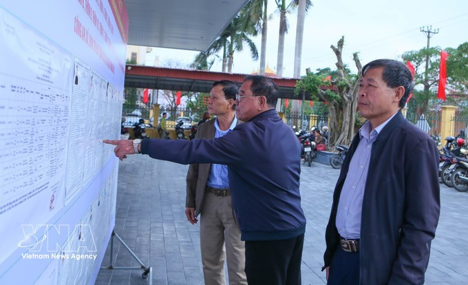 海进乡第三投票区的选民正在了解国会代表及各级人民议会代表候选人的相关信息。（图片来源：越通社）