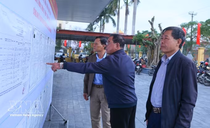 海进乡第三投票区的选民正在了解国会代表及各级人民议会代表候选人的相关信息。（图片来源：越通社）