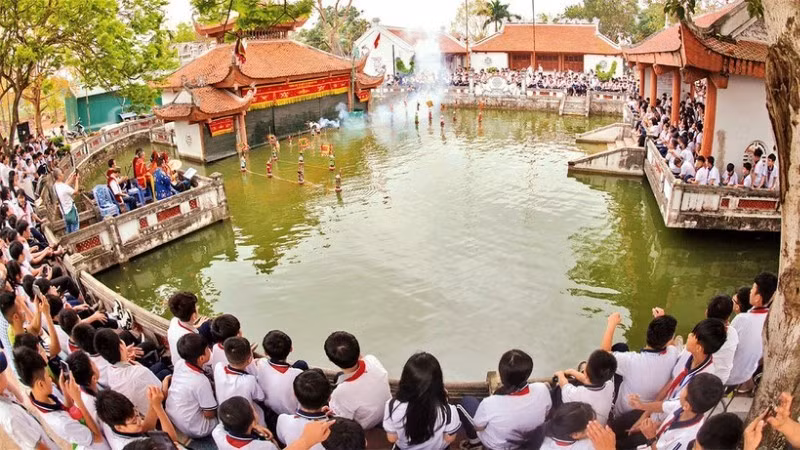 学生们在河内市书林村观看水上木偶戏表演。