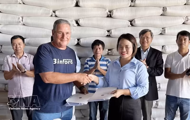 AgriVMA公司经理阮氏香与洛斯帕拉西奥斯农业公司总经理米歇尔·巴利亚特·卡梅霍共同签署交付合同。（图片来源：越通社）