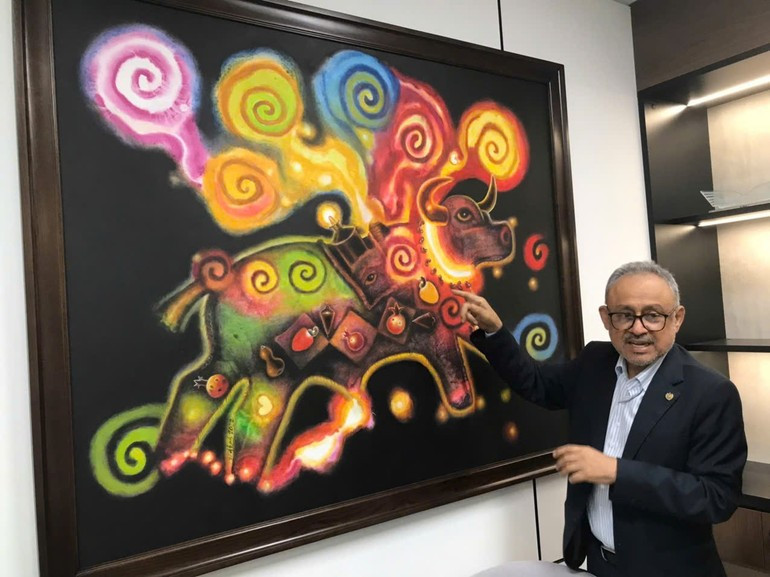 萨尔瓦多驻越南大使鲁本·奥马尔·奥罗斯科·布尔戈斯向各位代表介绍绘画作品。