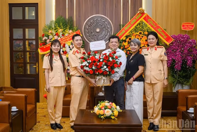 越南《人民报》社办公室副主任潘朋山与来访的越南公安部交通警察局副局长范越功大校和工作代表团合影。