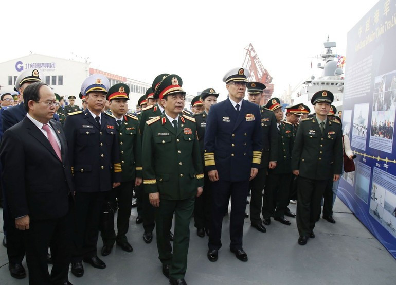 两位部长参观两国海军联合巡逻图片展。