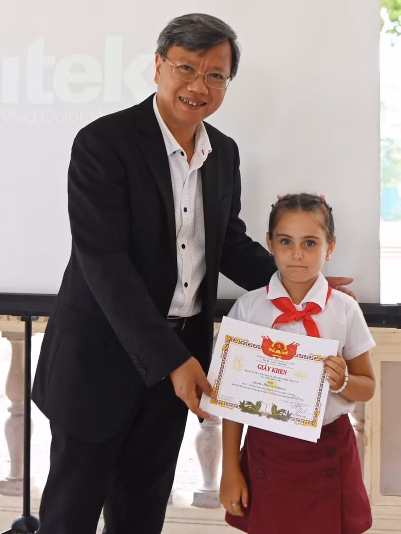 越南驻古巴大使黎光龙向一名获奖学生颁发奖状。（图片来源：越通社）