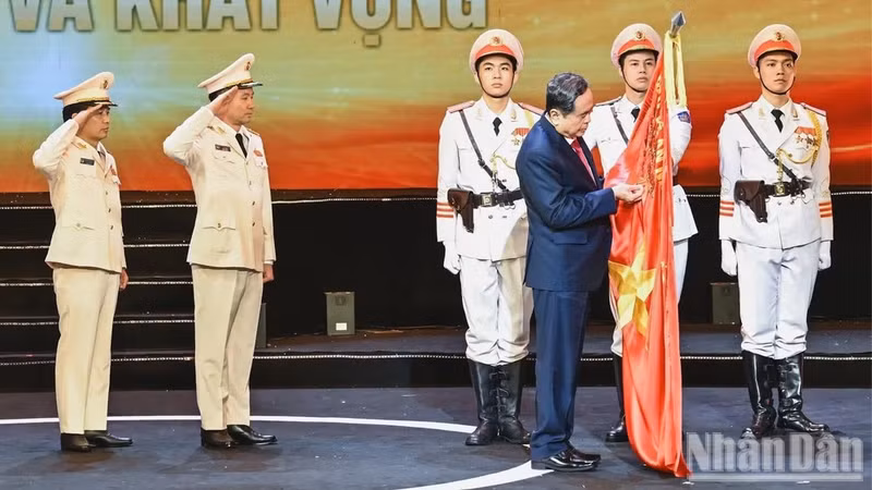 国会主席陈青敏将胡志明勋章佩挂在经济警察力量的传统旗帜上。（维灵 摄）
