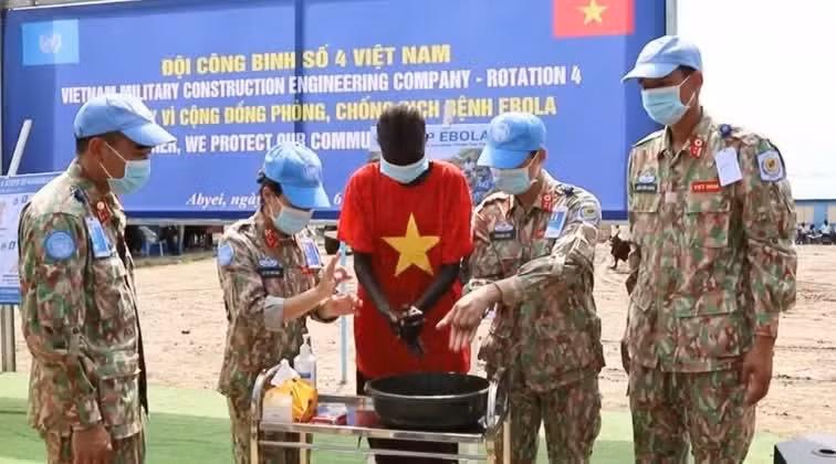 越南军医医护人员耐心地手把手指导，帮助当地学生熟悉标准医疗消毒流程。