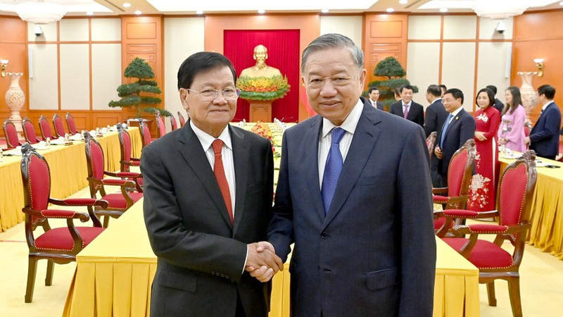 越共中央总书记苏林与老挝人民革命党中央总书记、国家主席通伦·西苏里亲切握手合影。