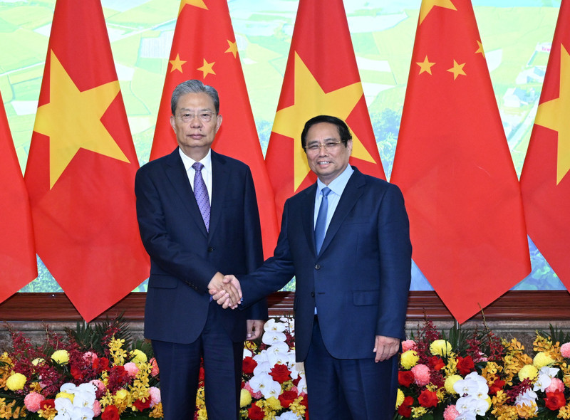 越南政府总理范明正与中共中央政治局常委、中国全国人大常委会委员长赵乐际亲切握手合影。