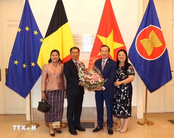 老挝驻比利时大使金福克·蓬玛哈赛向越南驻比利时大使阮文草赠送鲜花。（图片来源：越通社）