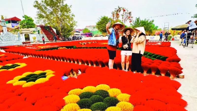 游客在南升龙文化遗产线路上的广富球制香村打卡留念。